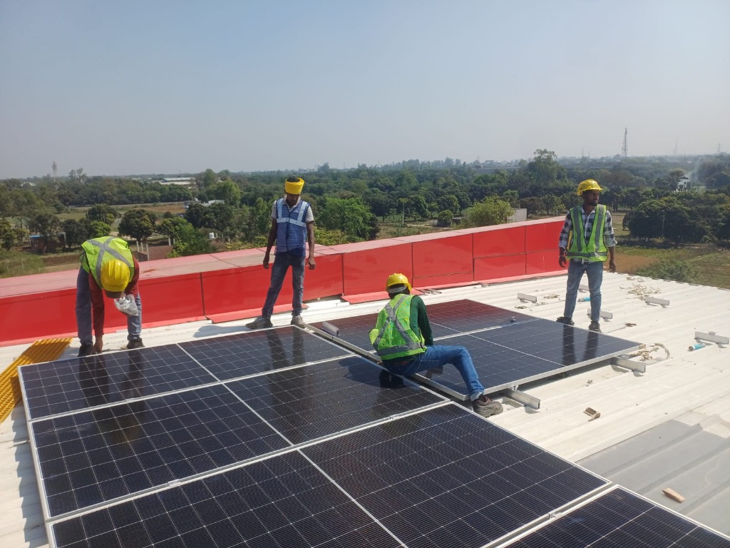 Vykon Indus EPC crew installing solar panels on commercial rooftop — Uttar Pradesh, India
